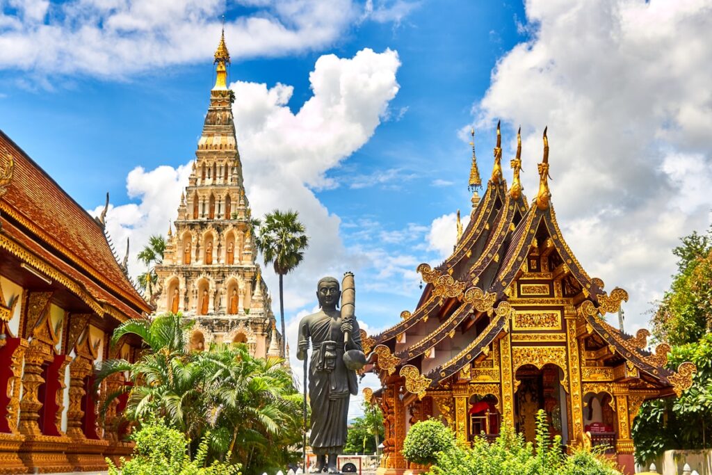 Golden Buddhist temple spires against a clear blue sky in Bangkok Thailand representing affordable travel from India